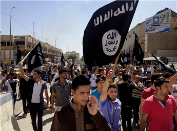 Demonstrators carry Islamic State flags through the streets of Mosul, Iraq, on June 16, 2014. AP
